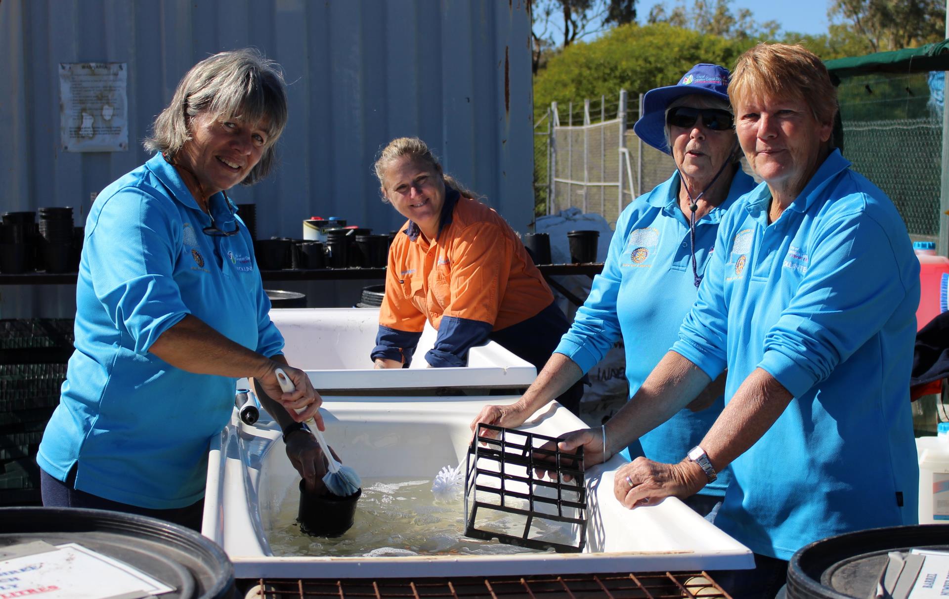 Community Nursery Officer Jeanette Reynolds (orange shirt) joins Community Nursery volunteers (from left) Anna Beyer, Cathy Barbour and Robyn Clements to wash pots and seedling tube trays in preparation for the next growing season.