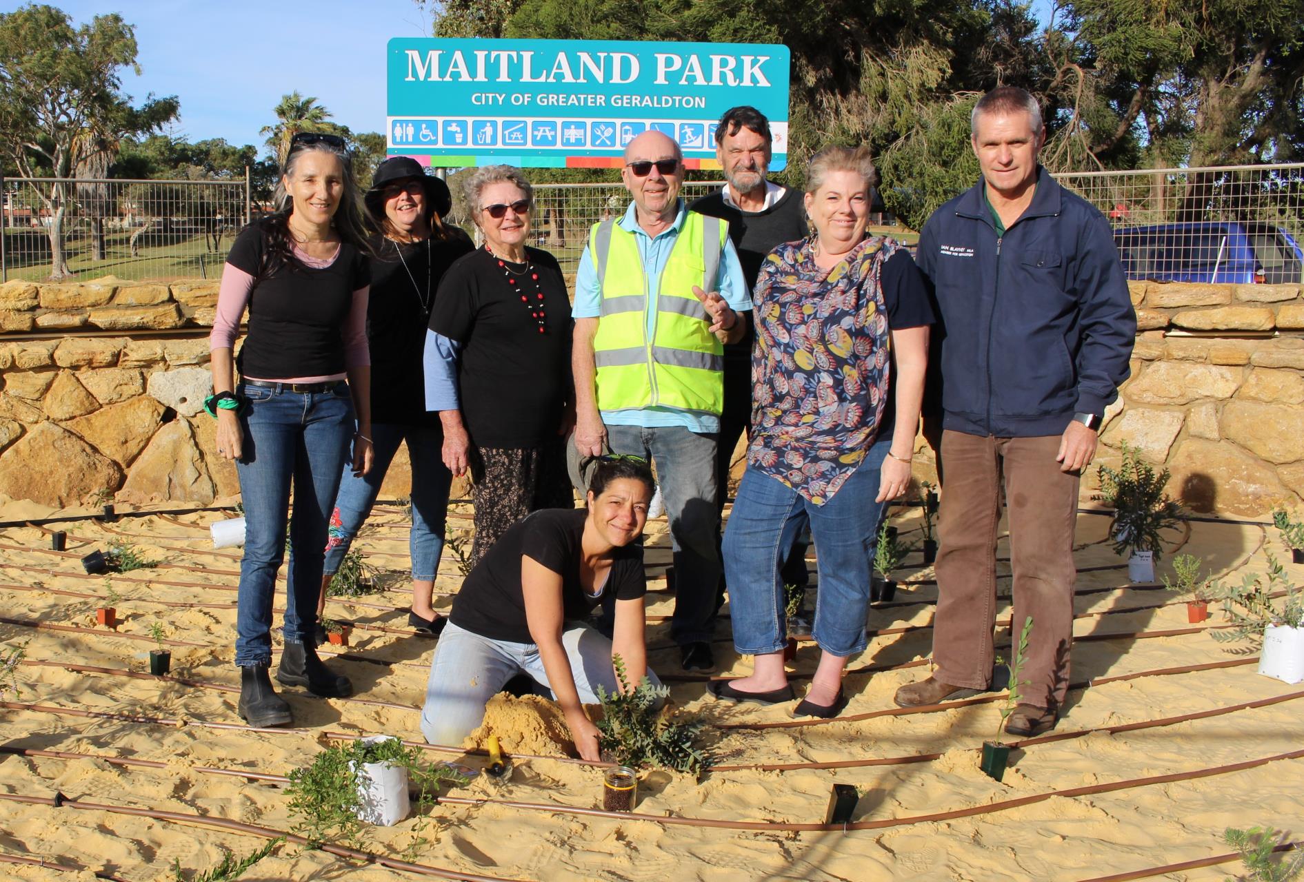 Group photo of first seedling being planted at Maitland Park
