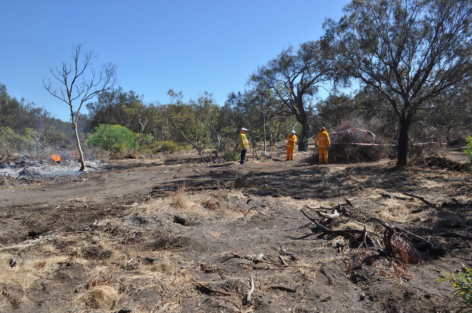 Volunteer Firefighters conducting a controlled burn of piles of African boxthorn at the ‘Rum Jungle’.